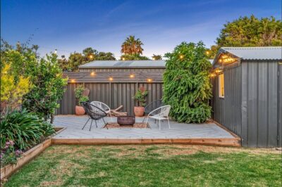 Port Noarlunga South backyard firepit area at dusk Paved backyard firepit area with festoon lighting after a full house renovation